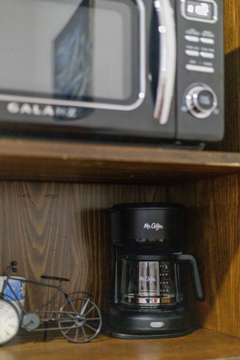 Mini kitchenette with microwave, fridge, coffee maker & toaster.