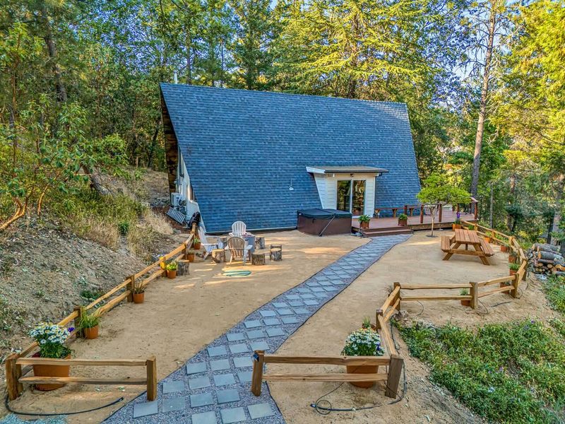 Backyard with walkway to backdoor and hot tub.