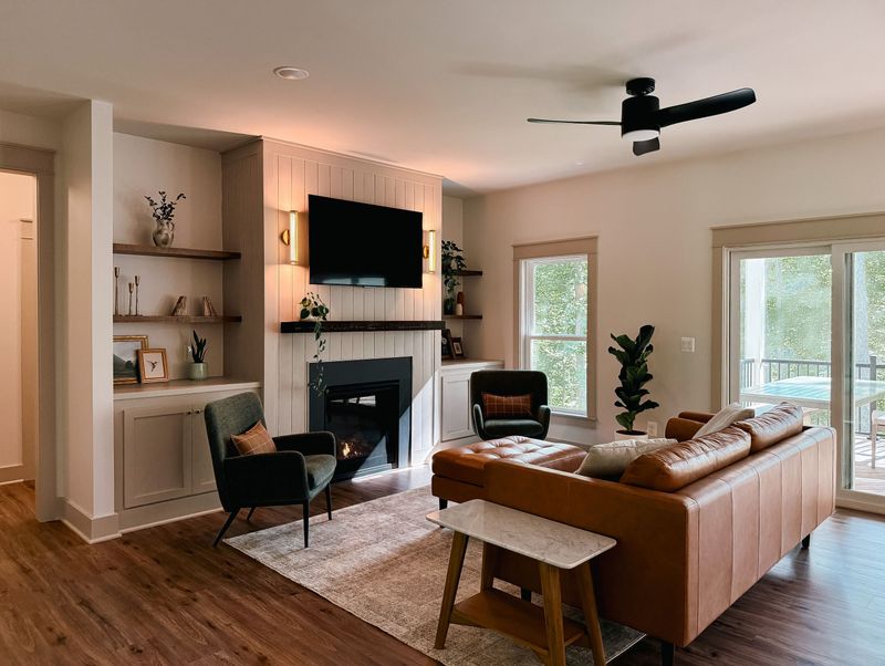 Cozy modern living room with fireplace, TV, and bright outdoor views