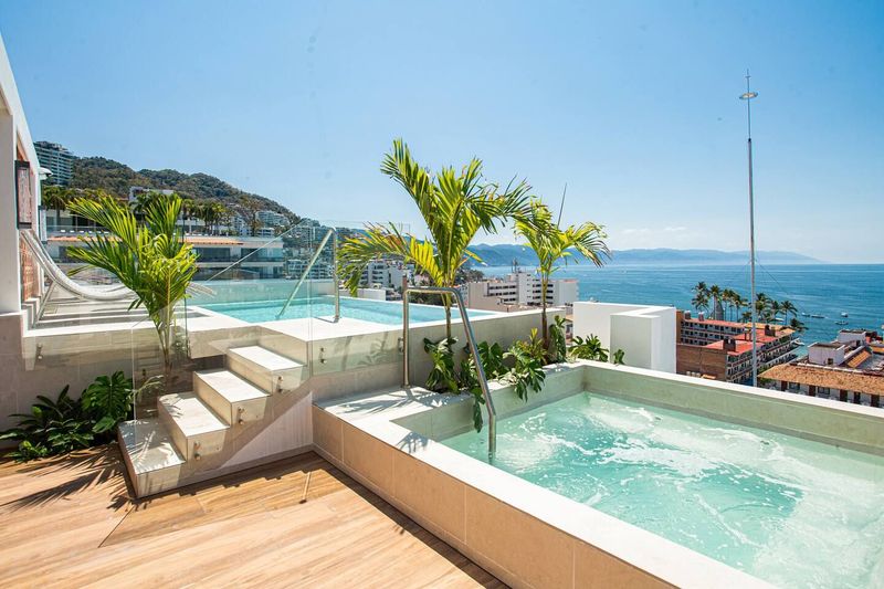 Soak in the hot tub or unwind by the rooftop shared pool with panoramic views