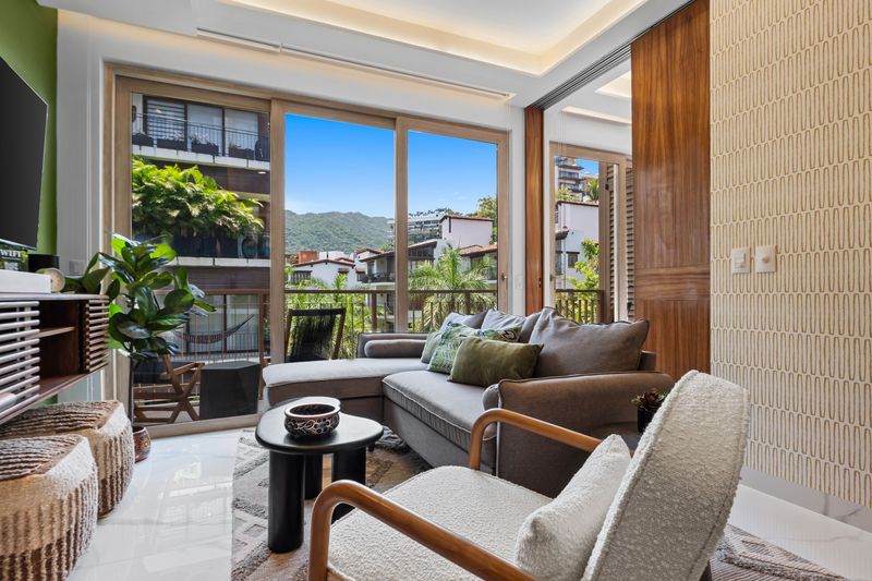 Settle into the stylish living room as Puerto Vallarta’s lush mountains provide a beautiful backdrop just beyond the glass.