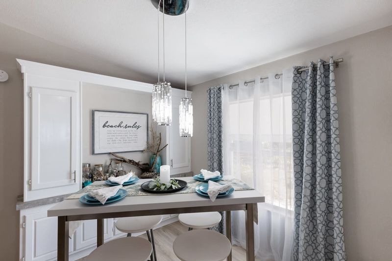 Gather around the dining table beside a large picture window overlooking tropical landscaping. It's the perfect place to enjoy meals, play games, or plan tomorrow's beach adventures in natural Florida sunshine.