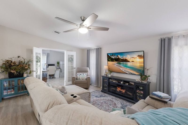 Relax on the plush sectional, stream your favorites on the Smart TV, or enjoy the cozy ambiance of the unique fireplace with glowing flames and your choice of heat or cool air. Coastal comfort meets modern style in this inviting gathering space.