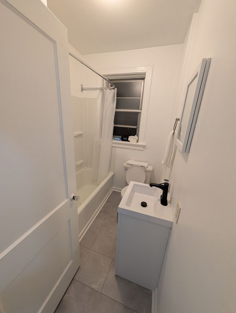 Bright modern bathroom with tub-shower combo and sleek updated finishes