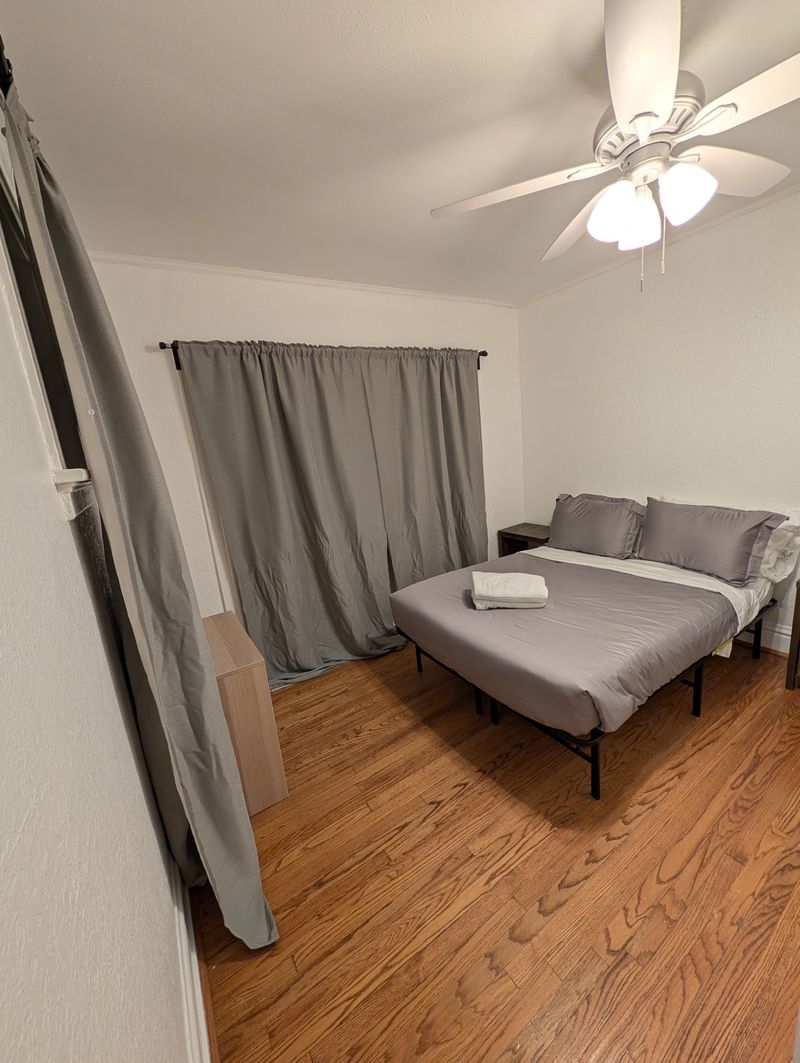 Cozy minimalist bedroom with blackout curtains and warm wood floors