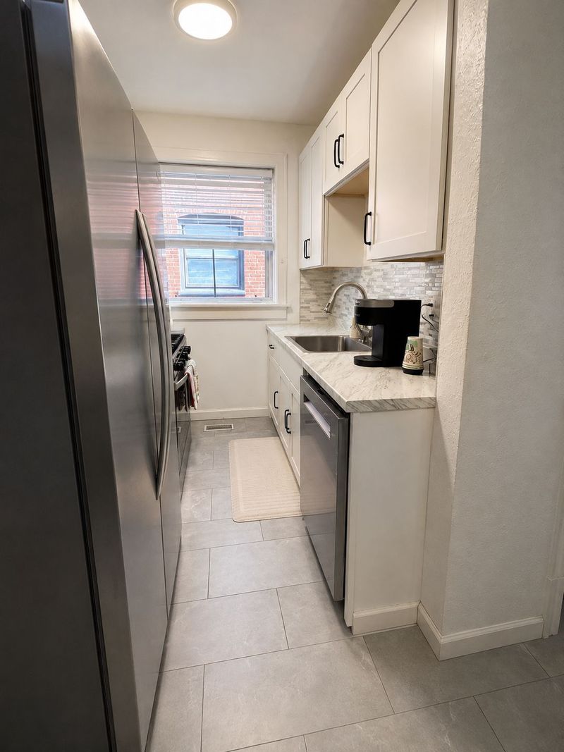 Bright modern galley kitchen with stainless appliances and natural light