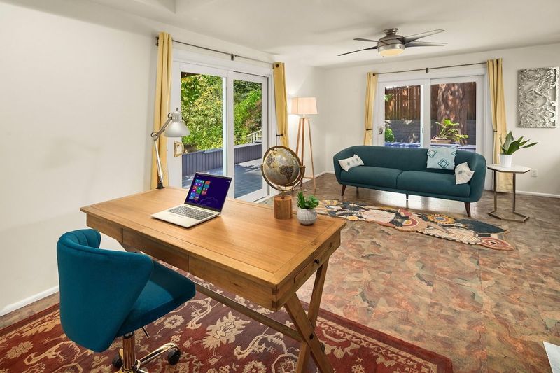 Overlooking the deck, this second living room area offers a sofa to enjoy the garden views, two sliding doors with access to the wrap-around deck as well as a large desk for any catch-up work. 