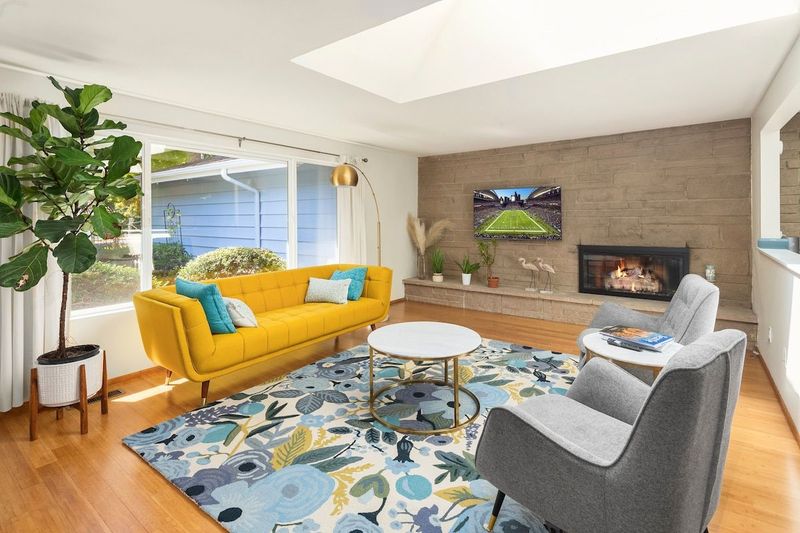 Carefully decorated in simple and elegant mid century modern style, the primary living room is filled with natural light from both the large windows and the skylights. Enjoy the 55 inch smart TV and the gas fireplace.  