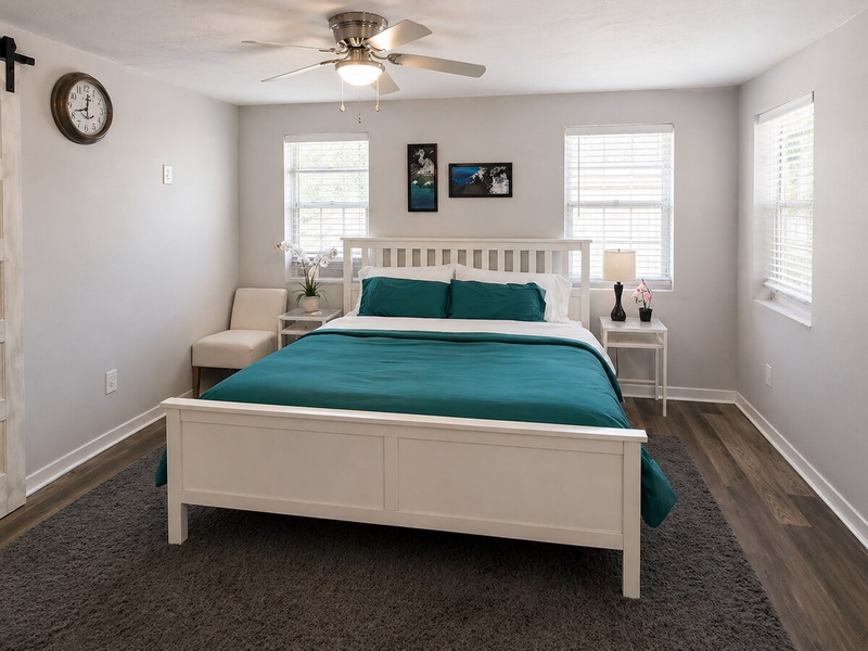 The primary bedroom includes a comfortable king bed and direct access to a private en-suite bathroom.
