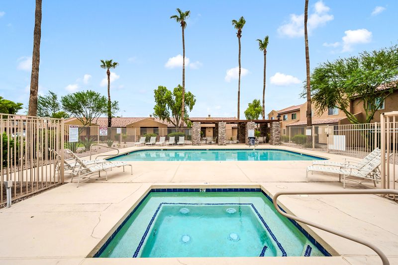 Resort-style pool and hot tub with palm-lined sun deck