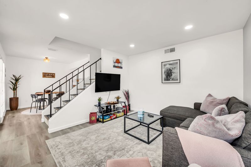 Bright modern living room with comfy sectional, TV, and dining nook