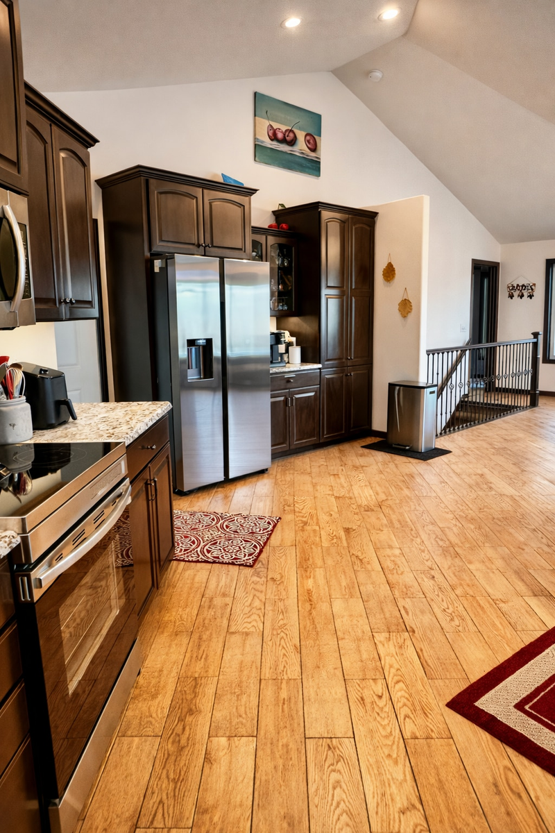 Spacious, open-concept kitchen featuring modern stainless steel appliances, including a refrigerator with water dispenser and ice maker. Enjoy pure, filtered water with the included ZERO water filter pitcher.