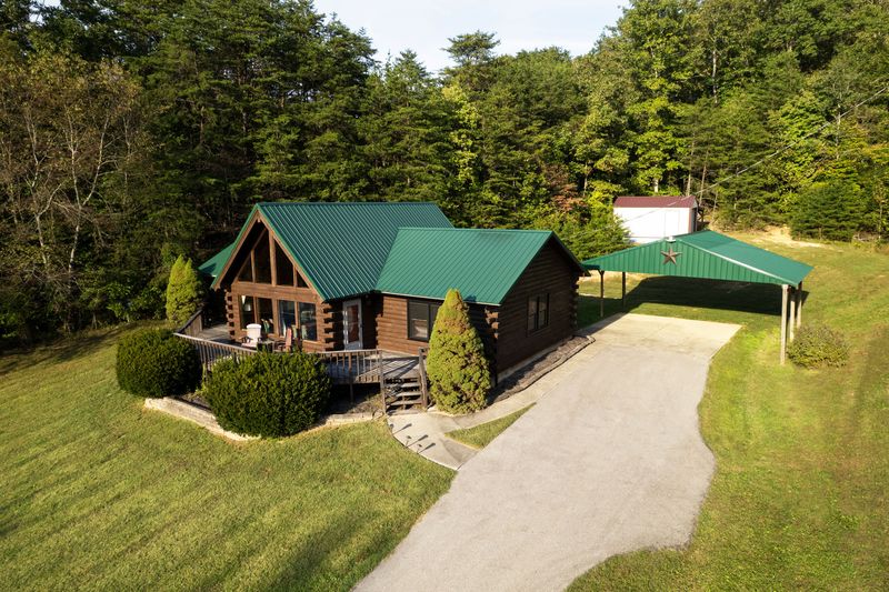 Private log cabin retreat with wraparound porch and wooded views
