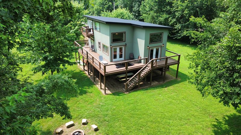 Private modern retreat with wraparound deck, lawn, and fire pit