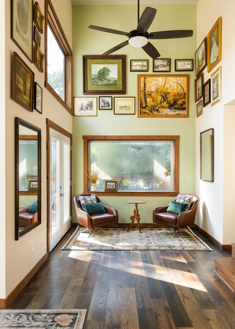 Sunny sitting nook with leather chairs, tall ceilings, and curated art