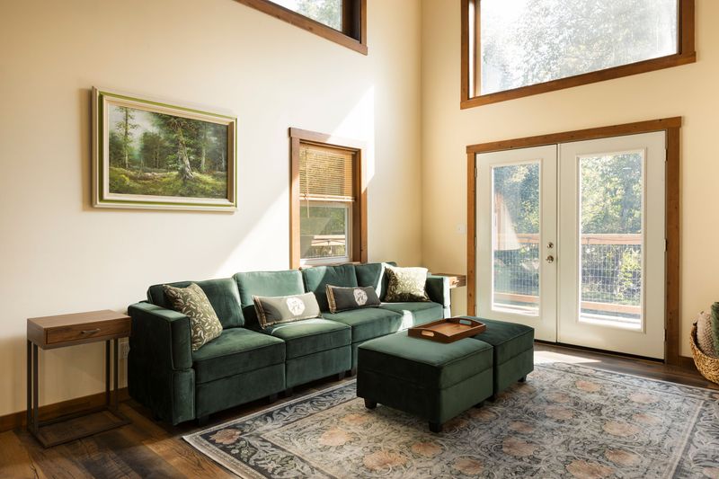 Sunlit living room with vaulted ceilings and deck access
